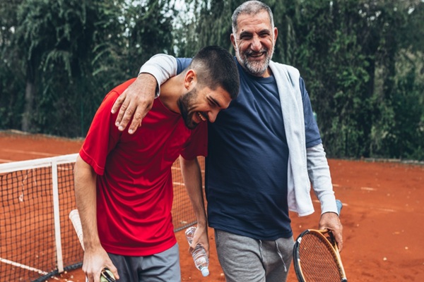 father and son embrace after a game of tennis