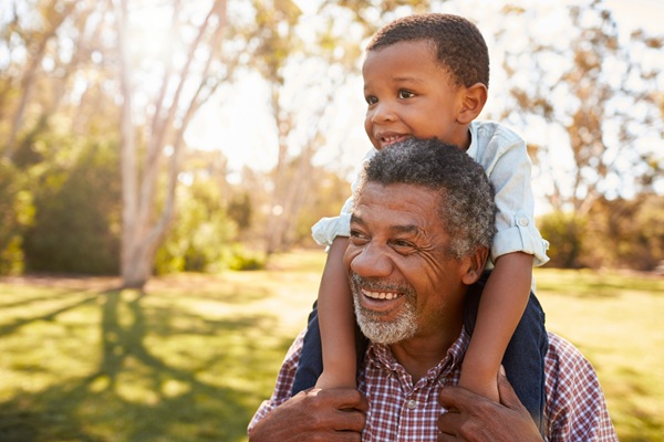 Grandpa walking with his grandson on his shoulders
