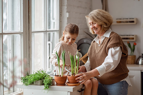 a woman and young girl watering house plants