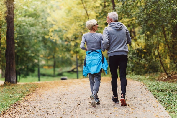 couple jogging together on a paved foot path